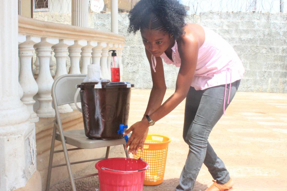 young lady washing her hands during COVID-19 Pandemic in Sierra Leone
