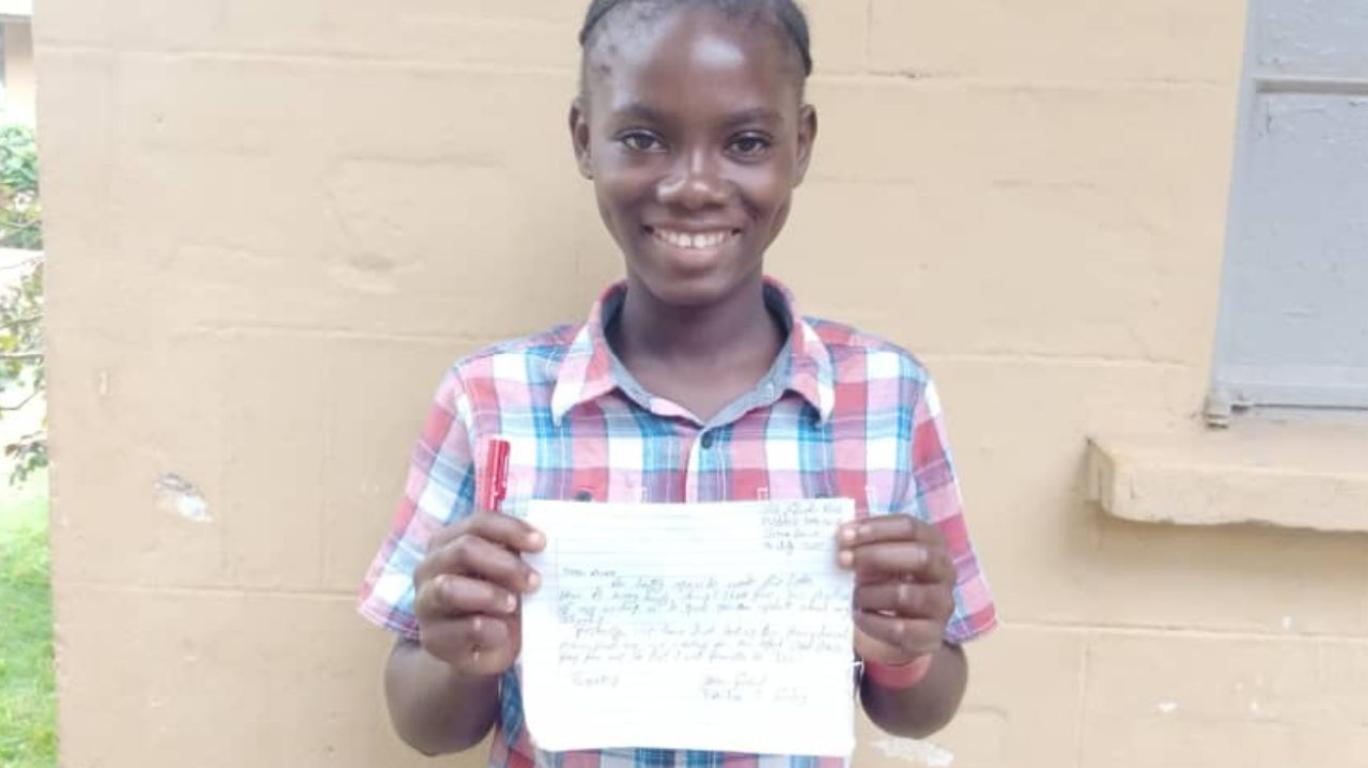 Jeneba with a letter to her sponsor