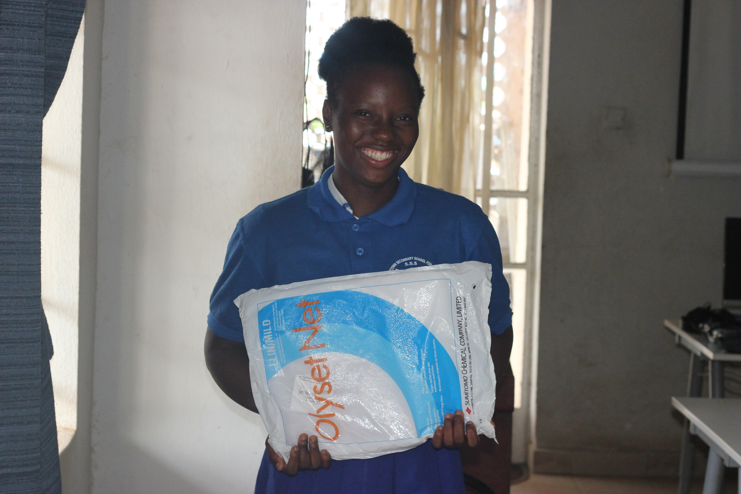 GRACE youth smiling holding mosquito net