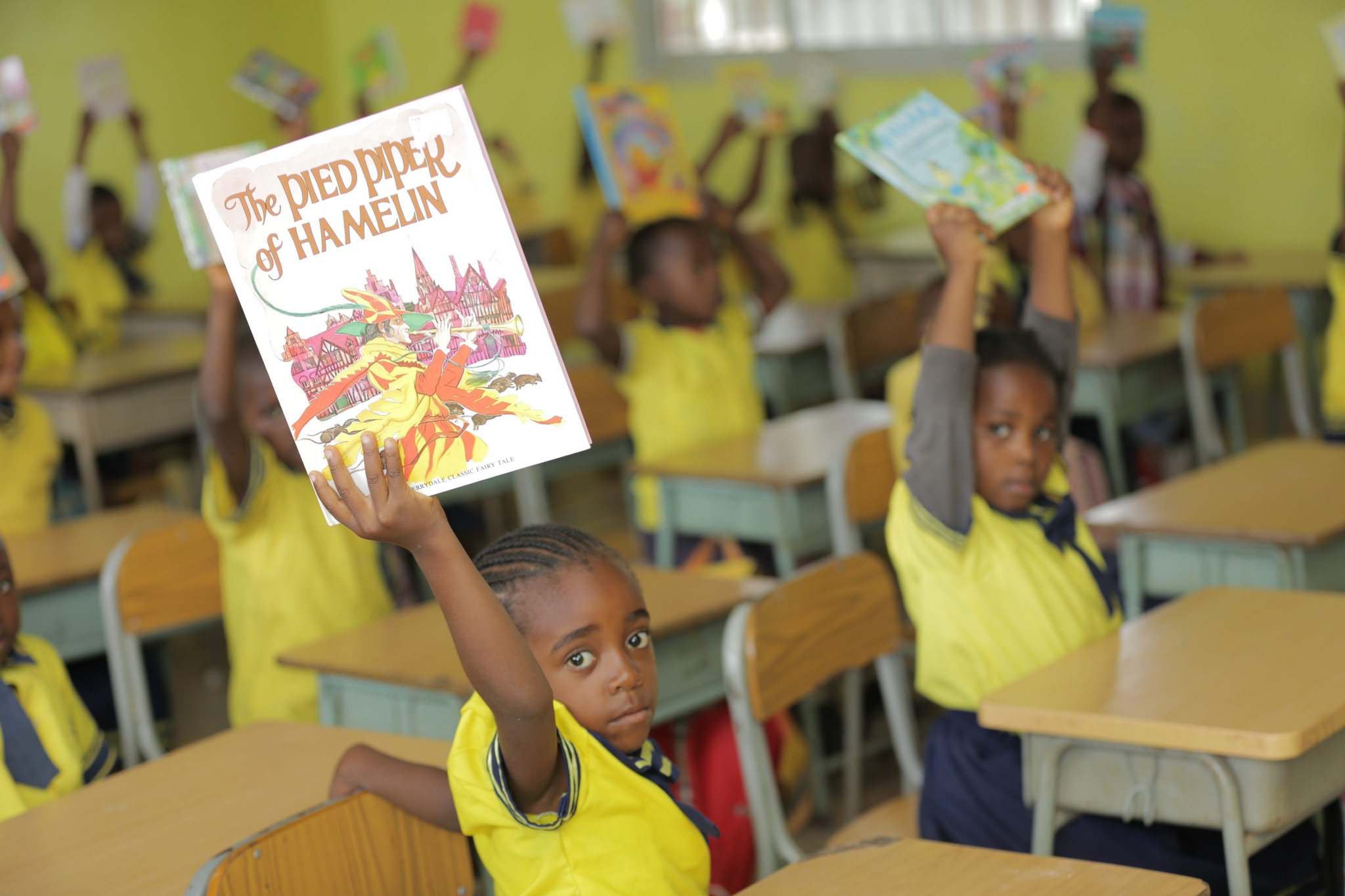 Kids in class displaying their books 