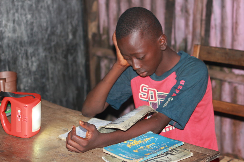 young man reading a book provided through donations 