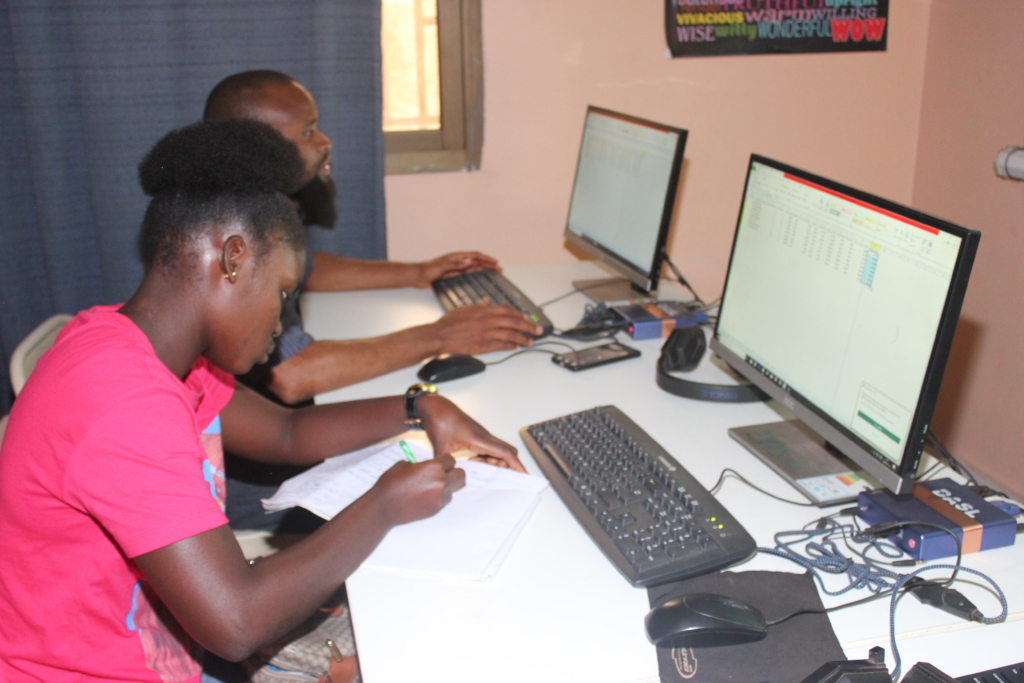 Youth leaning taking notes on computer training 