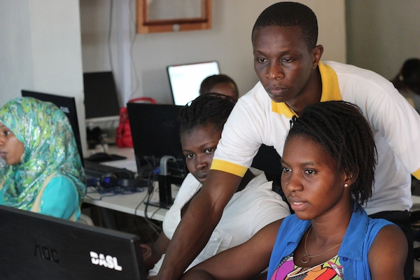 Johanese demonstrating computer usage to a student