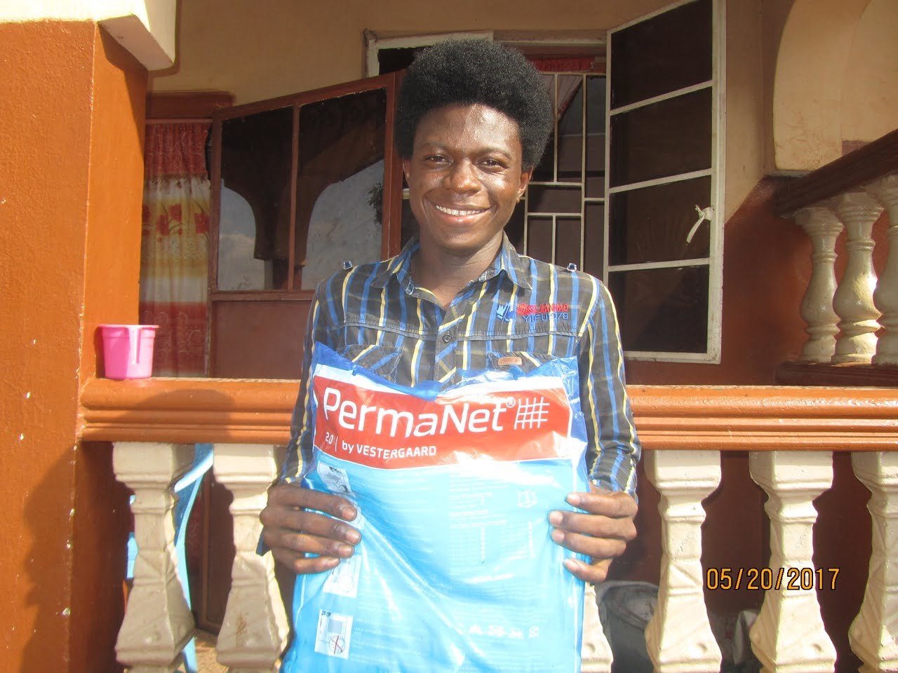 (c) Develop Africa. A boy with a mosquito net given to him by Develop Africa