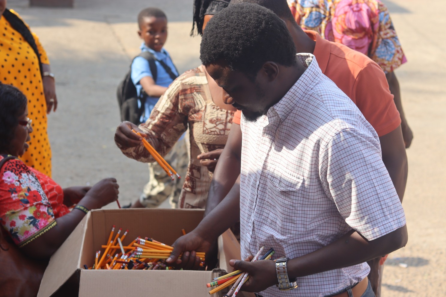Staffs of Develop Africa distributing pencils to pupils in a school in Sierra Leone.