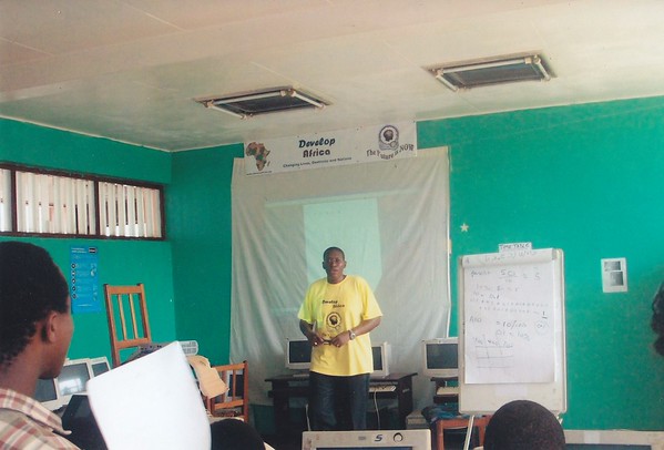 Sylvester in brigh yellow shirt teacking youths at the first learning session of Develop Africa in Sierra Leone