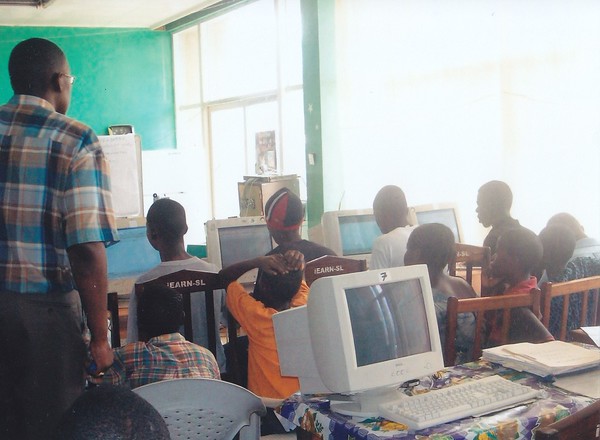 Sylvester in Sierra Leone teaching youths t use the computer