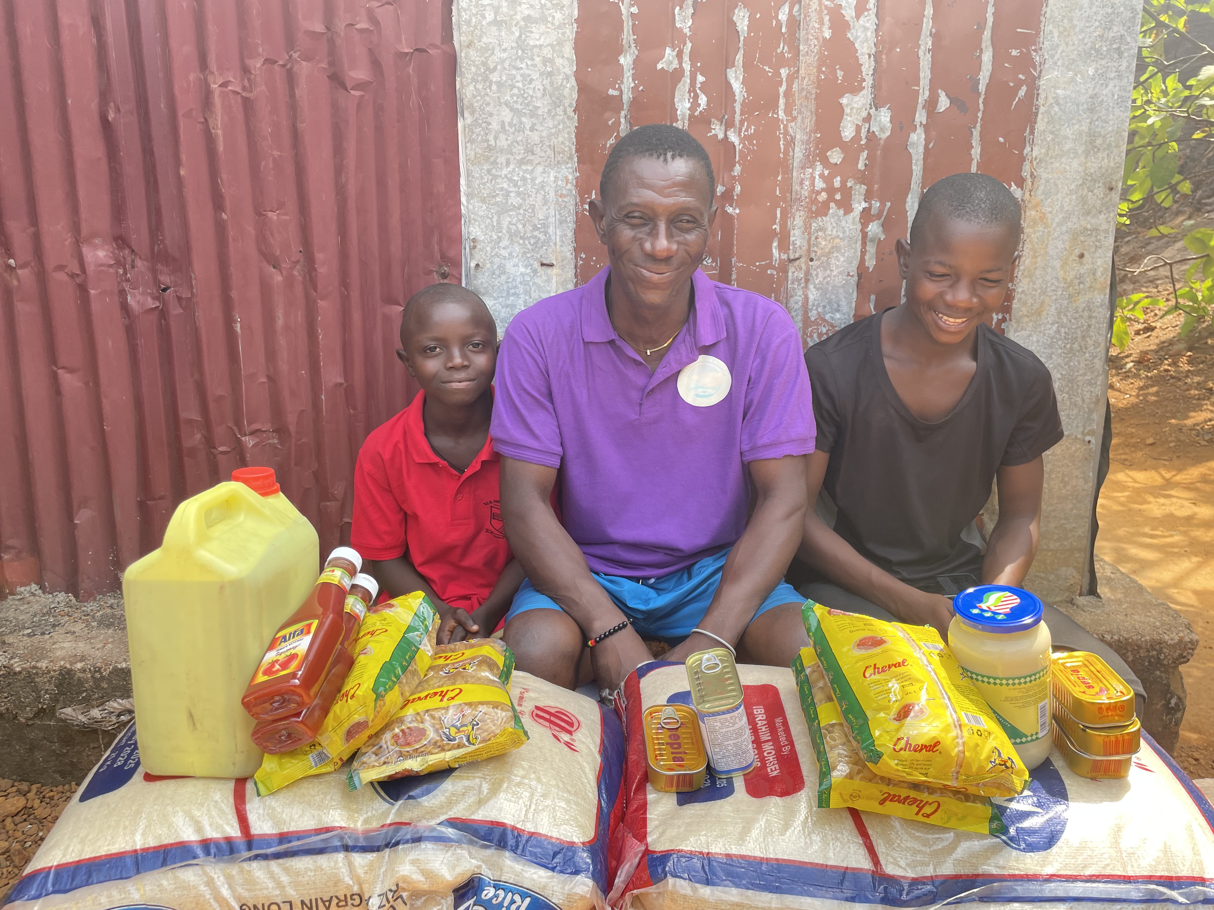 Isaiah and his family with food stuffs donated by Isaiah's sponsor