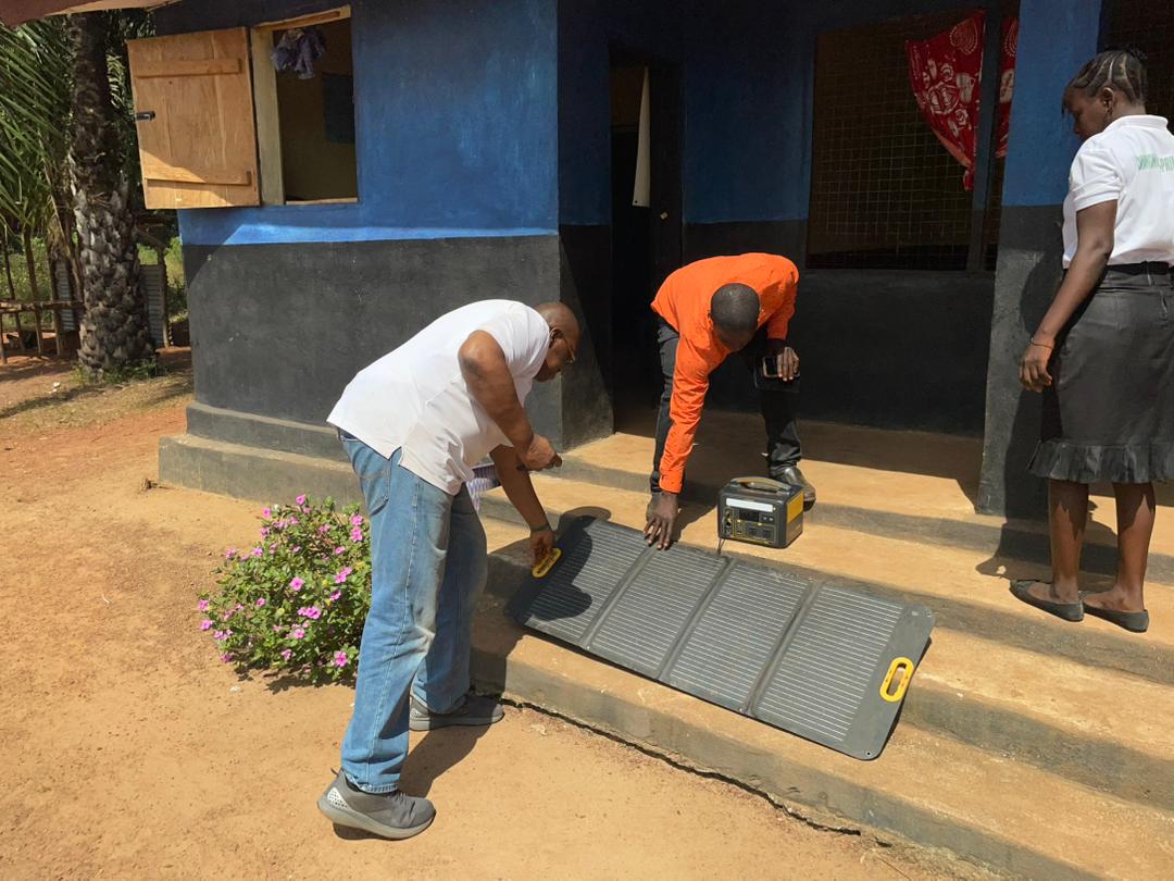 Sylvester with Kamawornie village people checking out one of the solar power provided by Develop Africa