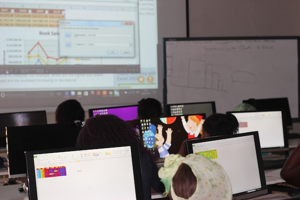 Students looking at a projected screen during a computer training session
