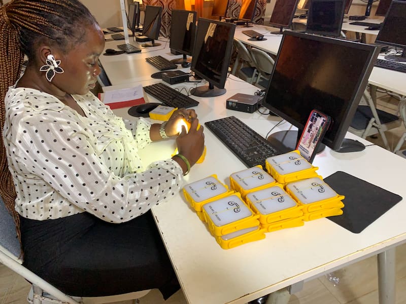 Staff Testing The Solar Buddy Lamp At Develop Africa Sierra Leone