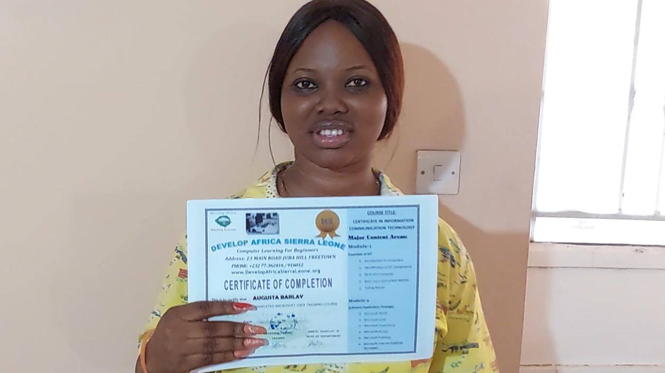 Augusta holding her Computer Training Certificate