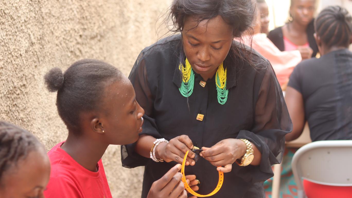 Entrepreneur Showing Girls How Make Bead Designs