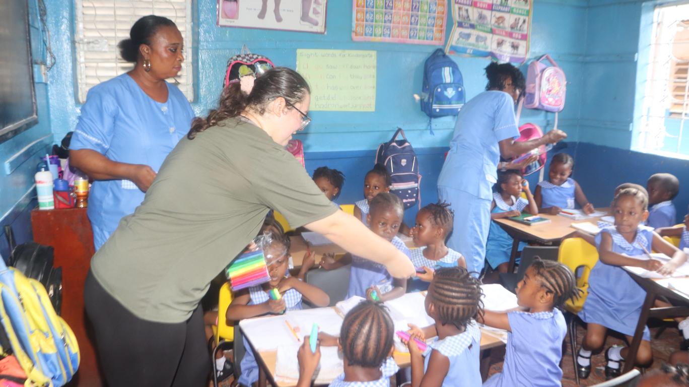 Olivia distributing school supplies at the FAWE School