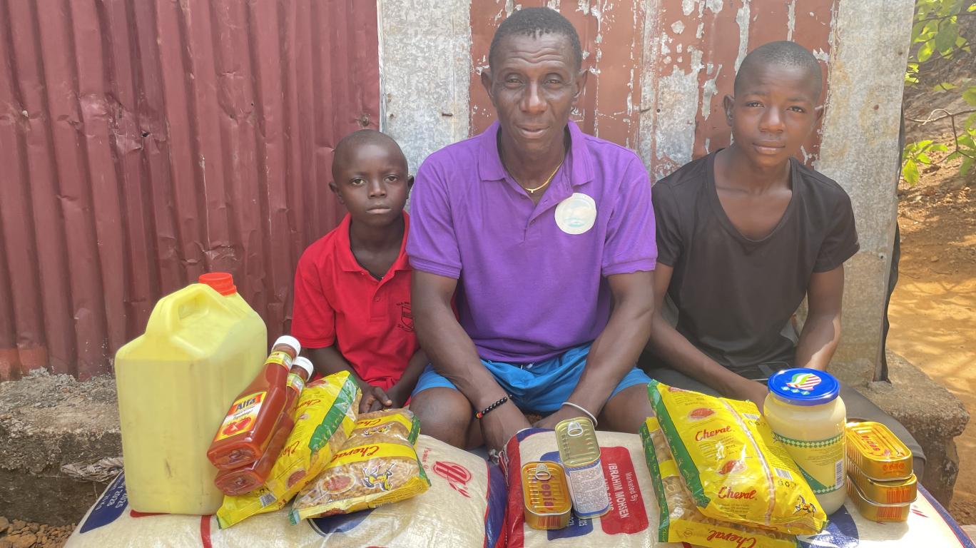 Isaiah and his family with food stuffs from his sponsor
