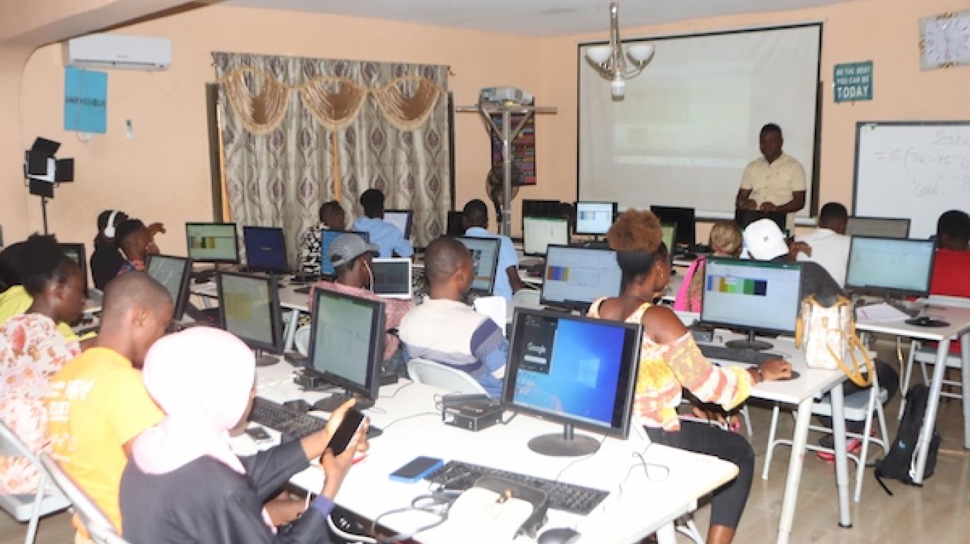 Students listening to instructor at the Develop Africa Siera leone computer lab teaching computer skills