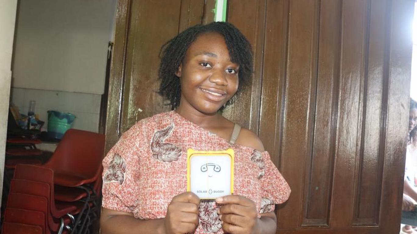 Shalina, University student holding a SolarBuddy lamp - Sierra Leone July, 2026