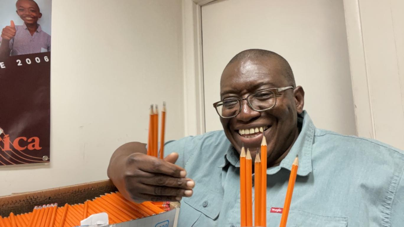 Sylvester smiling with a box of 1200 pencils