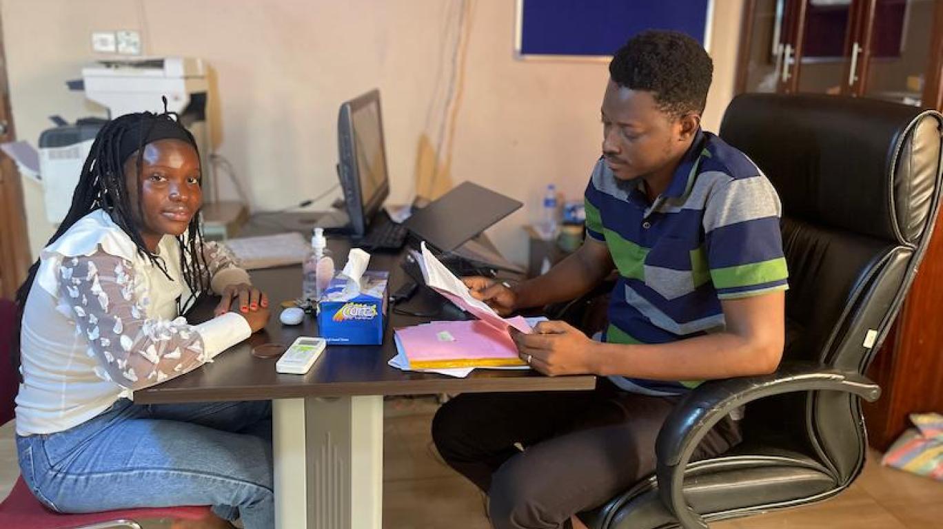 Joseph reviewing Yealie's report sheet, Develop Africa, 2026