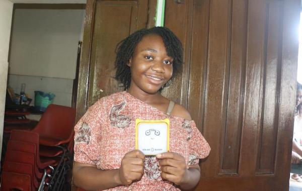 Shalina, University student holding a SolarBuddy lamp - Sierra Leone July, 2026