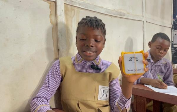 A student with SolarBuddy lamp - Sierra Leone, July 2026