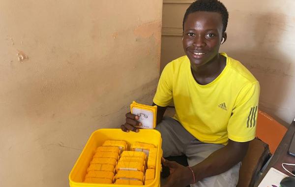 Volunteer Packing Solar Buddy Lamps In A Bucket - Sierra Leone