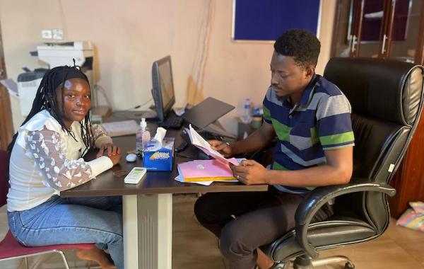 Joseph reviewing Yealie's report sheet, Develop Africa, 2026