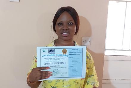 Augusta holding her Computer Training Certificate
