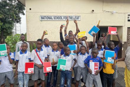 Students from the National School for the Deaf holding their new school supplies