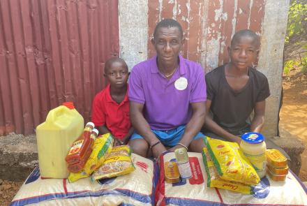Isaiah and his family with food stuffs from his sponsor