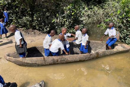 Children crossing the river to go to school in a canoe in Magbaikoli village