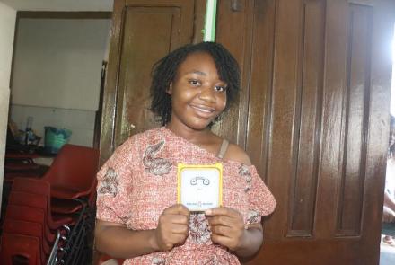 Shalina, University student holding a SolarBuddy lamp - Sierra Leone July, 2026