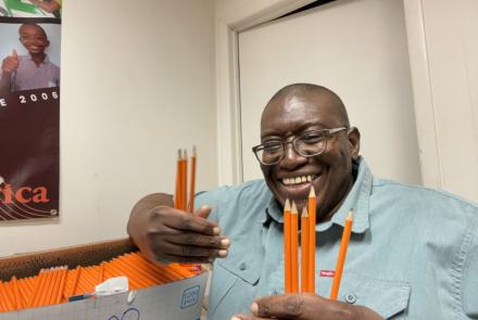 Sylvester smiling with a box of 1200 pencils