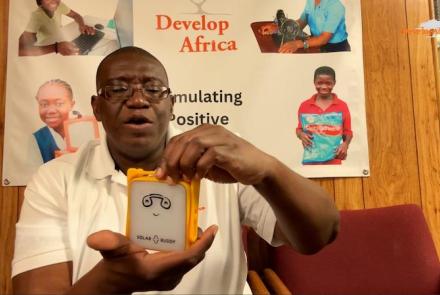 Sylvester Renner, Founder and President of Develop Africa holding a SolarBuddy lamp