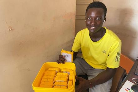 Volunteer packing SolarBuddy lamps in a bucket - Sierra Leone