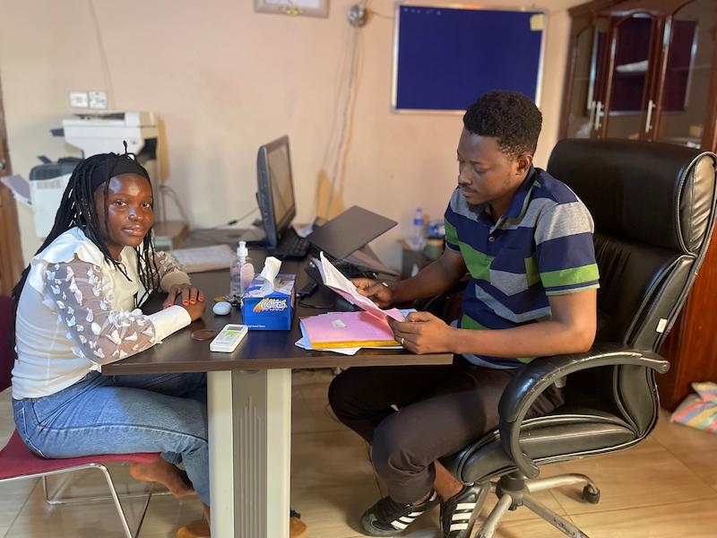 Joseph, reviewing Yeale's report sheet, Develop Africa, 2026